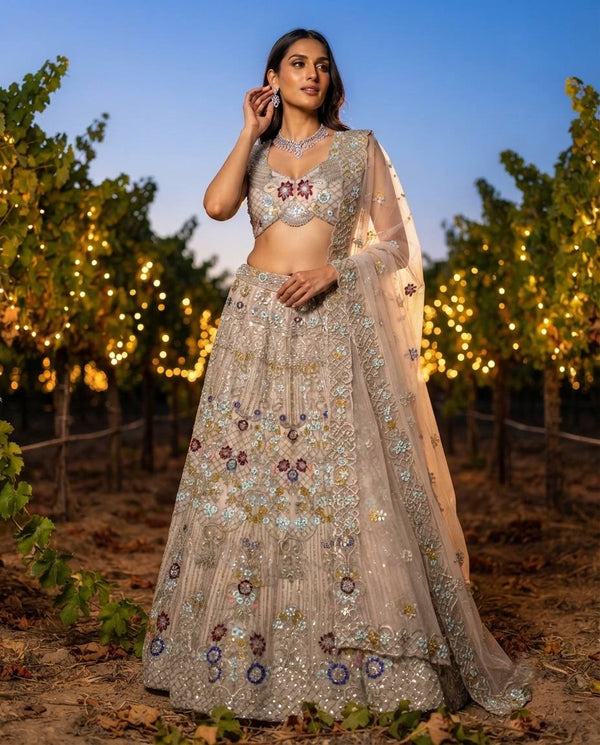 Elegant Pastel Beige Embroidered Net Lehenga Choli Set with Muted Floral Highlights and Sheer Dupatta