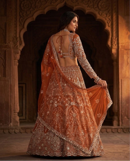 Rust Orange Heavily Embroidered Silk Lehenga Choli Set with Backless Tassel Detail and Intricate Silver Zari Work