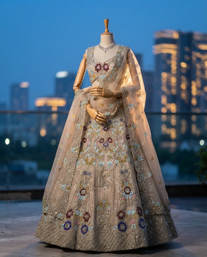 Elegant Pastel Beige Embroidered Net Lehenga Choli Set with Muted Floral Highlights and Sheer Dupatta